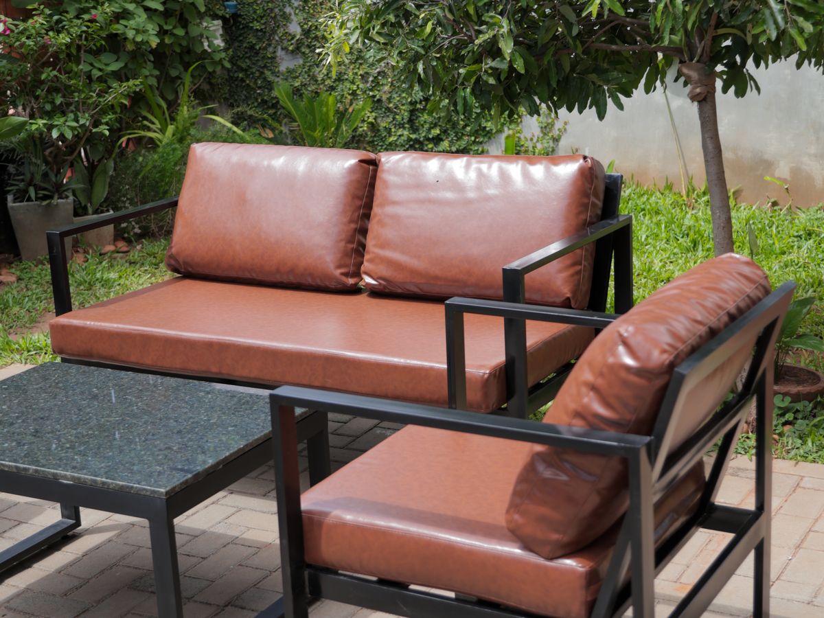 Sofá y sillón del juego Aura en marrón, al sol